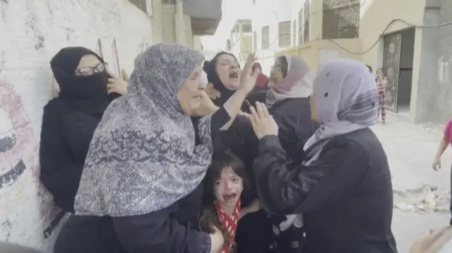 Women and a child wailing in grief during a funeral procession in Rafah