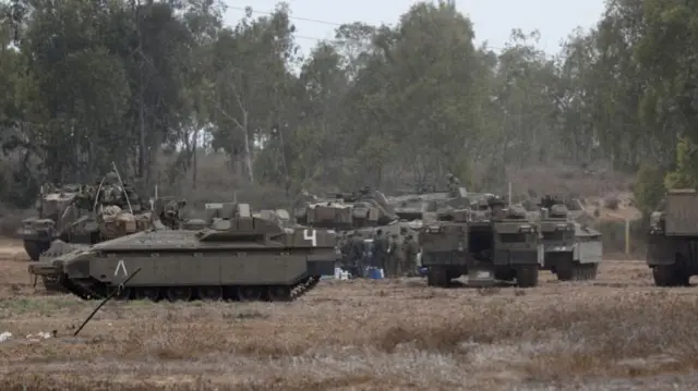 Israel's troops and military vehicles gather next to the border with Gaza