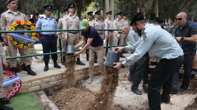 Soldiers cover the grave with soil