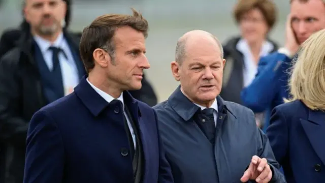 German Chancellor Olaf Scholz and French President Emmanuel Macron walking and talking.