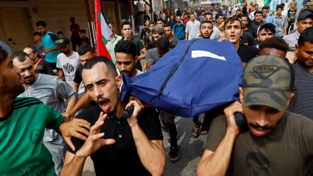 Mourners carry the body of a Palestinian through the streets of Rafa