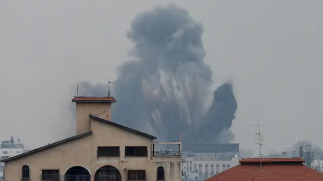 Smoke rises between building in Gaza after Israeli missile strikes