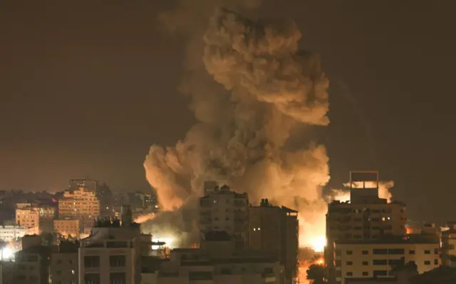 Fire and smoke rise above buildings in Gaza during an Israeli air strike