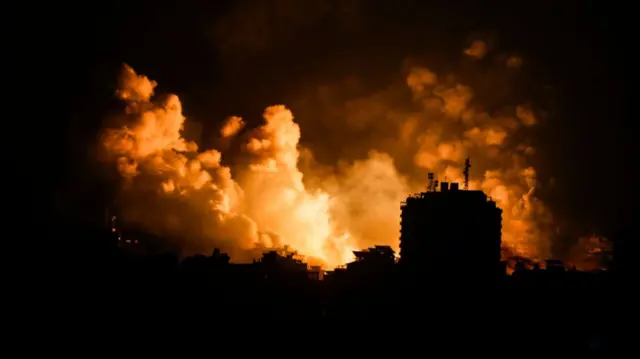 A smoke rises and ball of fire over a buildings in Gaza City on October 9, 2023 during an Israeli air strike.