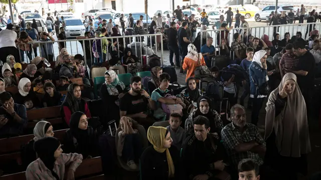 Palestinians wait to cross into Egypt at the Rafah border crossing between the Gaza Strip and Egypt