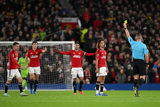 Hannibal Mejbri of Manchester United is shown a yellow card