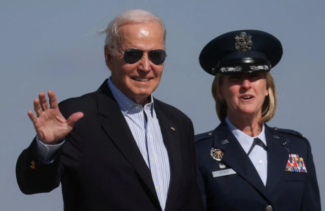 U.S. President Joe Biden, accompanied by Colonel Angela Ochoa, walks to board the Air Force One as he departs on travel to Minnesota