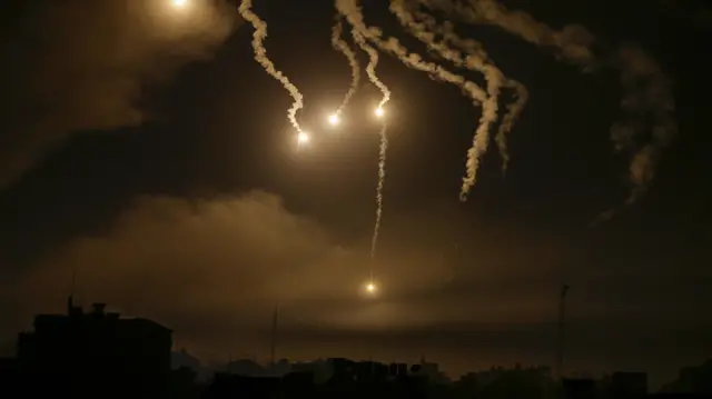 Israeli army flares illuminate the sky over northern Gaza City, 31 October 2023.