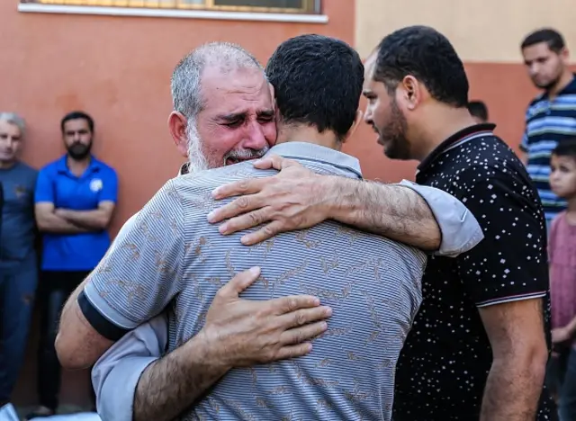 Dozens of Palestinians gathered outside the Nasser Hospital morgue waiting to get the bodies of their relatives for burial.