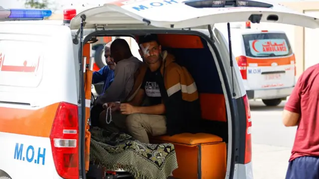 An injured Palestinian man sits in an ambulance, as he waits for medical workers to take him to receive treatment in an Egyptian hospital, at the Rafah border crossing with Egypt, in the southern Gaza Strip, November 1, 2023.