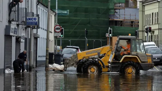 A truck helps people put sandbags outside a Newry shop