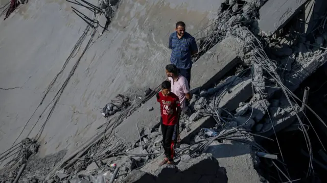 Palestinians search for bodies and survivors among the rubble in Fallujah in the Jabalia area