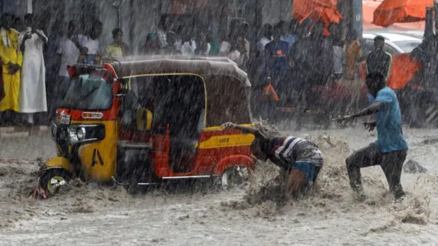 A man attempts to rescue a boy from raging flood waters following heavy rains in Mogadishu, Somalia November 9, 2023