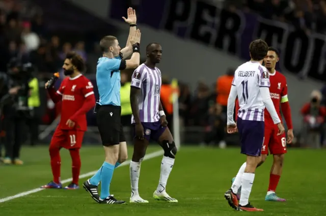 Referee Georgi Kabakov signals a handball following a VAR check and disallows Liverpool's third goal