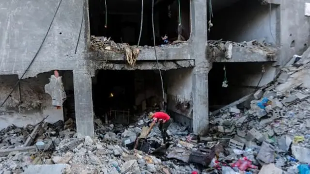 People search through buildings, destroyed during Israeli air raids in Khan Yunis