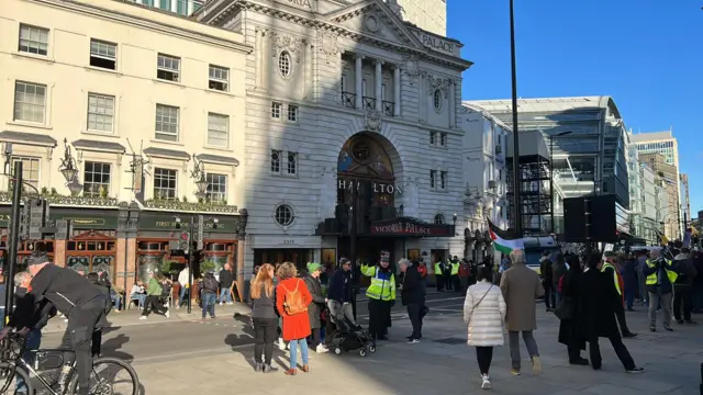 A group of protestors are seen in the plaza outside Victoria Station