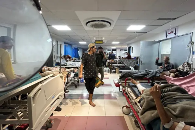 A man walks through a corridor in Al-Shifa hospital, where beds are full