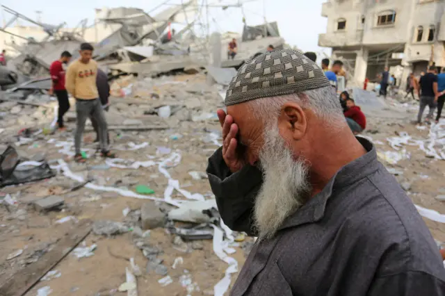 Palestinians survey the rubble after Israeli air strikes hit houses in Rafah