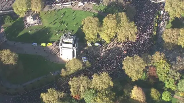 A view over central London showing crowds of people marching