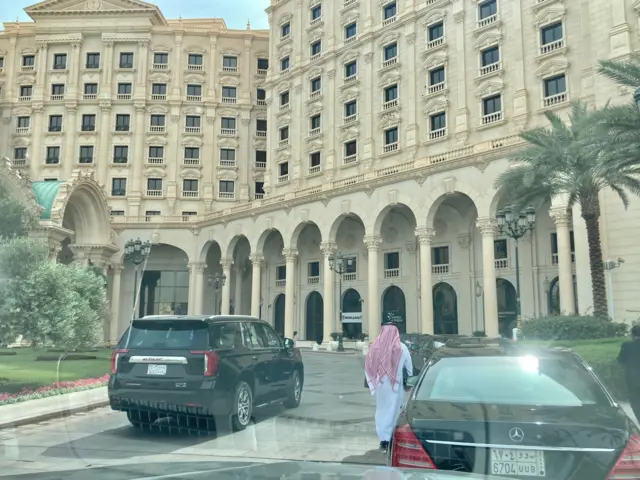 A man walks towards a lavishly decorated stone building
