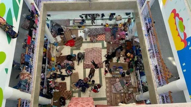 A high-angle view looking down through the different floors of Rantisi hospital shows civilians sheltering from conflict
