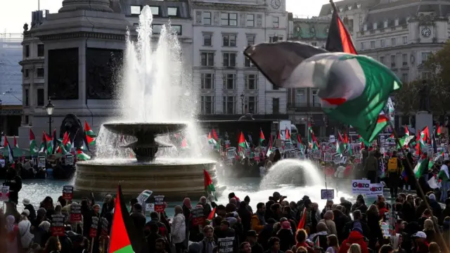 A large crowd in London's Trafalgar Square holding Palestinian flags and placards