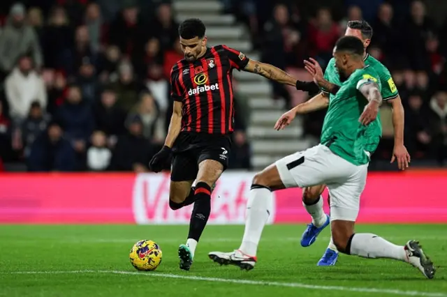 Dominic Solanke shoots as Jamaal Lascelles slides to block