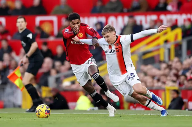 Marcus Rashford of Manchester United and Alfie Doughty challenge for the ball