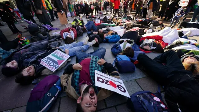 People take part in a die-in ahead of a Scottish Palestine Solidarity Campaign demonstration in Glasgow