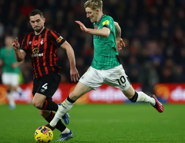 Antony Gordon on the ball with Lewis Cook in the background running