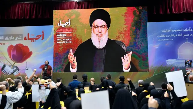 Hassan Nasrallah appears on a big screen in front of his supporters