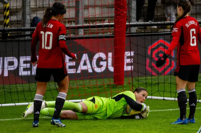 Earps gathers the ball close on the floor as her defender shield her.