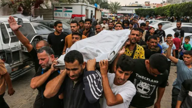 People mourn as they carry the bodies of Palestinians killed in Israeli airstrikes