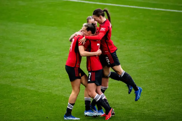 United players celebrate at full time after a big win.