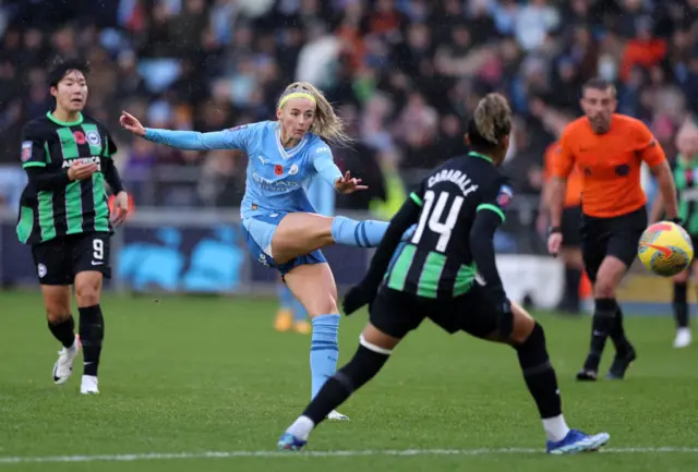 Kelly shoots at goal as a Brighton defender tries to get in the way.