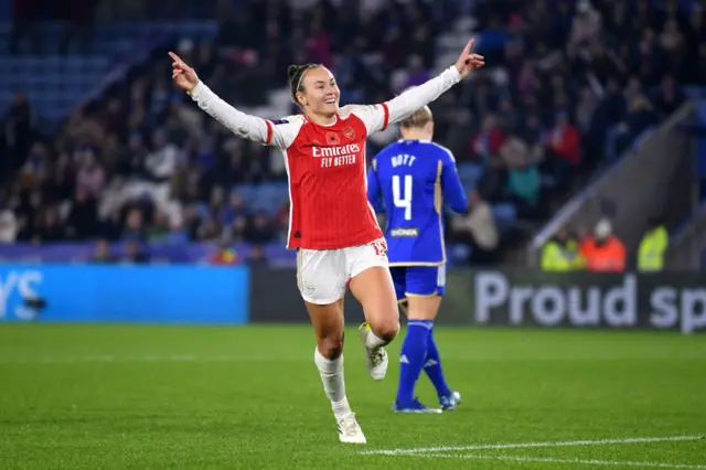 Caitlin Foord raises her arms to celebrate her goal.