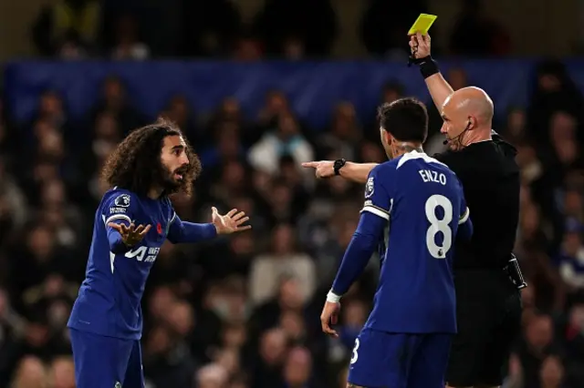 Anthony Taylor shows a yellow card to Marc Cucurella