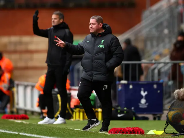 Matt Beard and his assistant wave instructions to the Liverpool players.