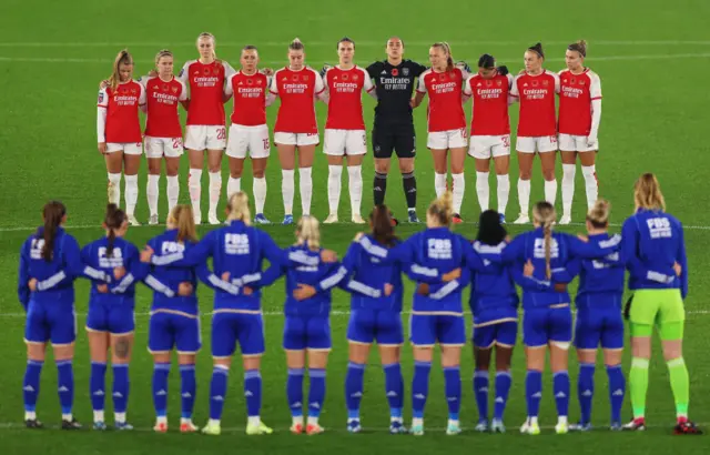 Players stand around the centre circle and observe a remembrance day minute's silence.