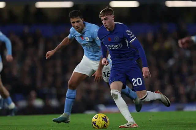 Cole Palmer runs with the ball as Ruben Dias pursues him