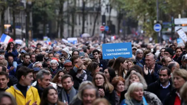 A crowd marches through central Paris