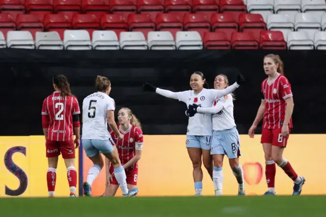 Ebony Salmon is hugged and greeted by teammates after doubling the lead for Villa surrounded by Bristol players on their knees.