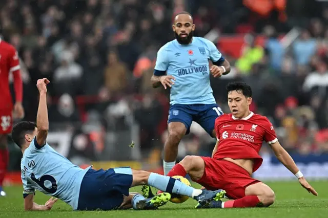 Wataru Endo slides into a tackle on Brentford's Danish midfielder Christian Norgaard