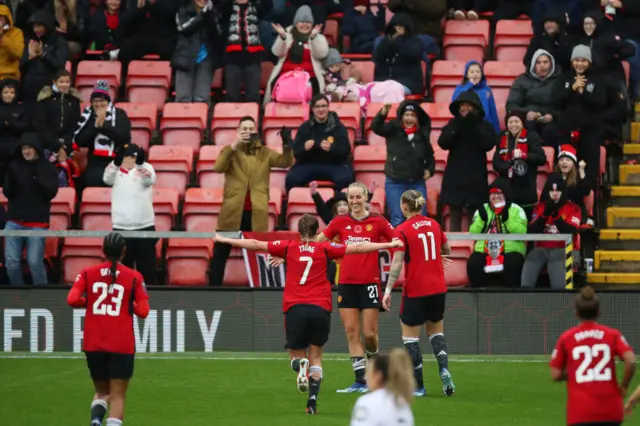 United players run to Turner to celebrate her goal.