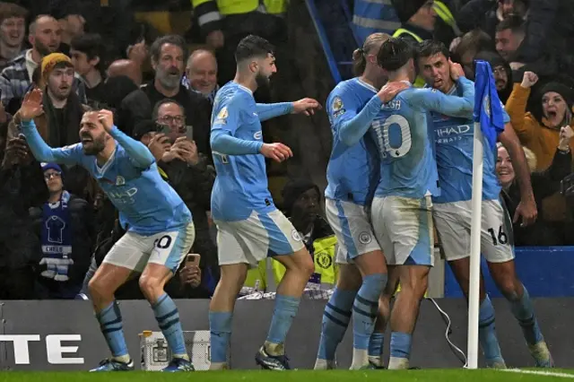 Man City players celebrate their fourth goal near the corner flag