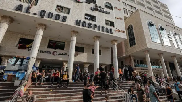 People gather on the steps of Al-Quds hospital