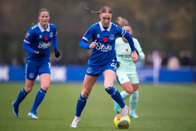 Holmgaard dribbles the ball forward with a Chelsea player in pursuit.