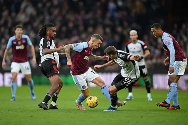 Lucas Digne of Aston Villa on the ball whilst under pressure from Alex Iwobi and Timothy Castagne