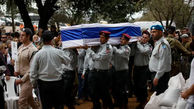 Israeli soldiers carry the a coffin draped in the Israeli flag