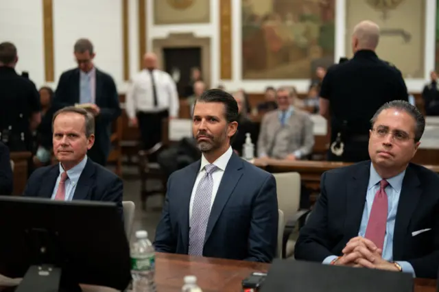 Donald Trump Jr (middle) with his lawyers